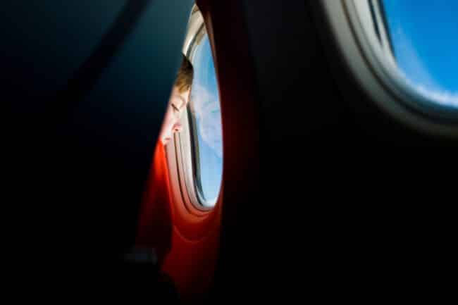 ילד מסתכל בחלון של מטוס